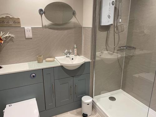 uma casa de banho com um lavatório e um chuveiro em Limetrees em Keswick