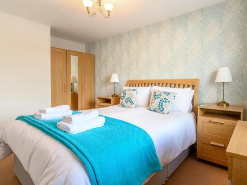 a bedroom with a large bed with towels on it at Limetrees in Keswick