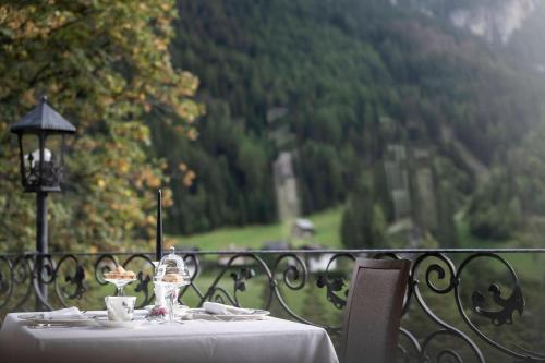 uma mesa com uma toalha de mesa branca e óculos em Chalet Hotel Hartmann - Adults Only em Ortisei