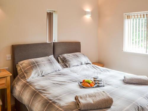 a bed with a plate of fruit on it at The Pump House in Cawston