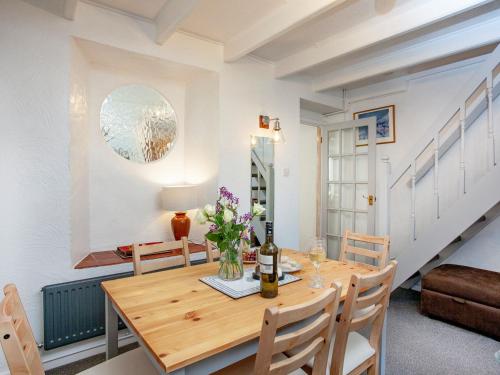 a dining room with a wooden table and chairs at Delius in Penryn