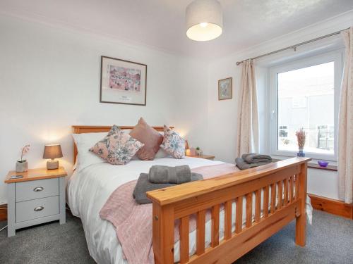 a bedroom with a large bed and a window at Delius in Penryn