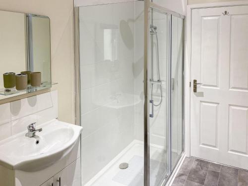 a white bathroom with a shower and a sink at Deer Cottage 2 Uk39332 in Biddenden