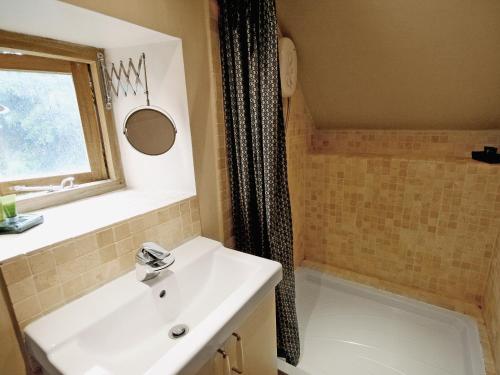 Highpeak Junction的住宿－Cornstore Cottage，一间带水槽和淋浴的浴室