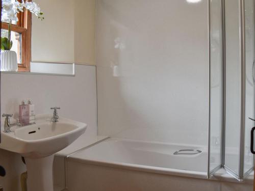 ein Badezimmer mit einem Waschbecken, einer Dusche und einer Badewanne in der Unterkunft Beck Foot Cottage in Sedbergh