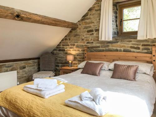 a bedroom with a bed with towels on it at Tawny Owl Barn in Barlow