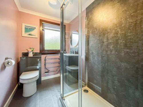 a bathroom with a toilet and a glass shower at Laroch Cottage in Ballachulish