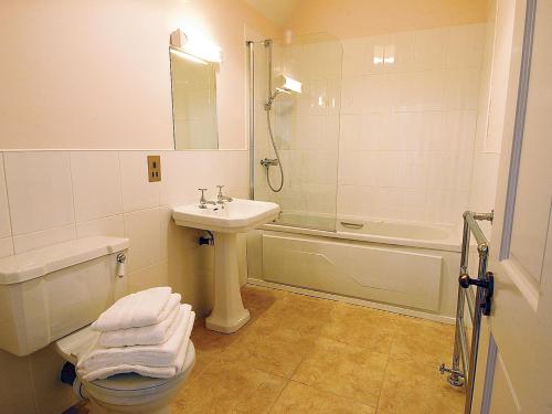 a bathroom with a sink and a toilet and a shower at The Clock House in Smailholm