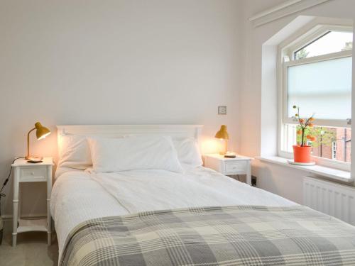 a white bedroom with a bed and two windows at Ouse Retreat in York