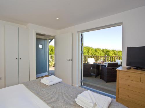 a bedroom with a bed and a sliding glass door at Una Aurum 56 in Carbis Bay