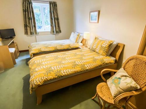 a bedroom with a bed and a couch and a chair at Friarystone Cottage in Bamburgh