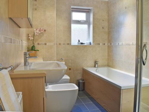 a bathroom with a sink and a tub and a toilet at Bay View West Wing in Carlyon Bay