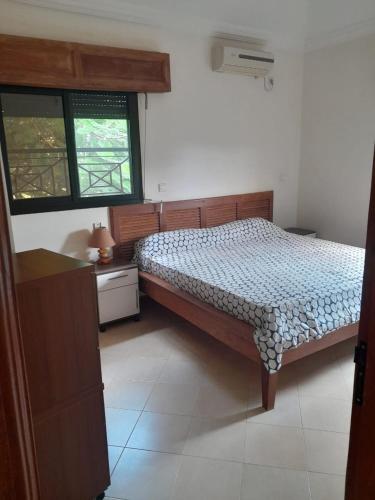 1 dormitorio con 1 cama y 2 ventanas en La chambre diambar, en Saly Portudal