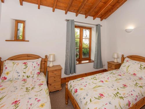 a bedroom with two beds and a window at Badger in Gunnislake