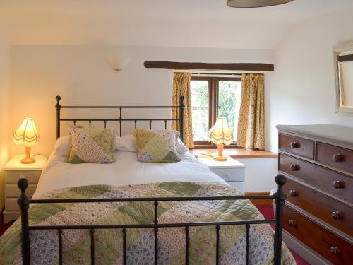 a bedroom with a bed with two lamps and a dresser at Orchard Barn - 16875 in Bampton