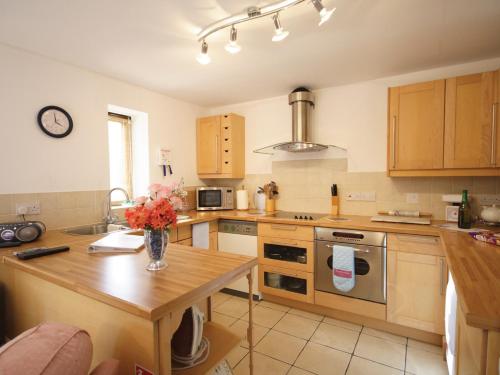 a kitchen with a table with a vase of flowers on it at High Farm Barn in Brisley