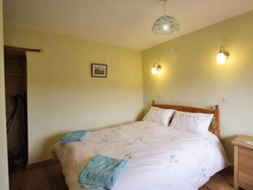 a bedroom with a large white bed with two pillows at The Brewhouse in Foxham