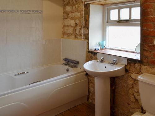 uma casa de banho com uma banheira e um lavatório em Guillemot Cottage em Flamborough