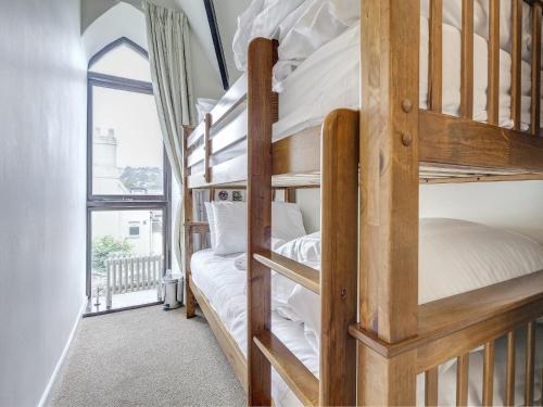 kilka łóżek piętrowych w pokoju z oknem w obiekcie 6 Torwood Gables w mieście Torquay