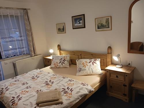 a bedroom with a bed and two tables and a window at Pension Ploc in Harrachov