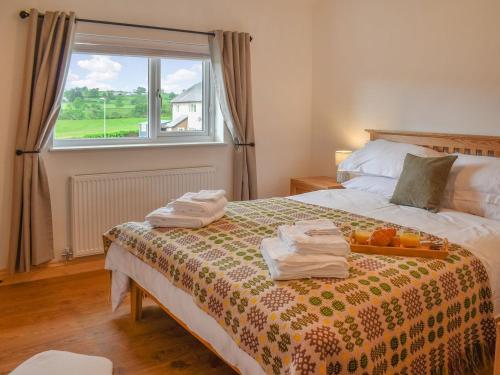 a bedroom with a bed with towels and fruit on it at Gwynfa - Uk39366 in Frongoch