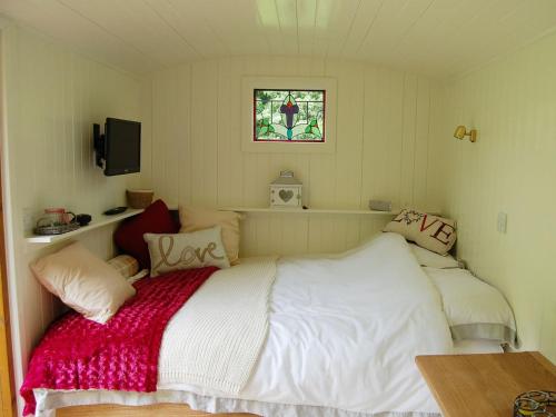 a small bedroom with a bed and a window at Beunos Hut -ukc4752 in Tremeirchion