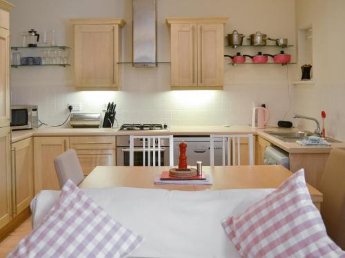 a kitchen with a table with two pillows on it at Percys Place in Alnwick