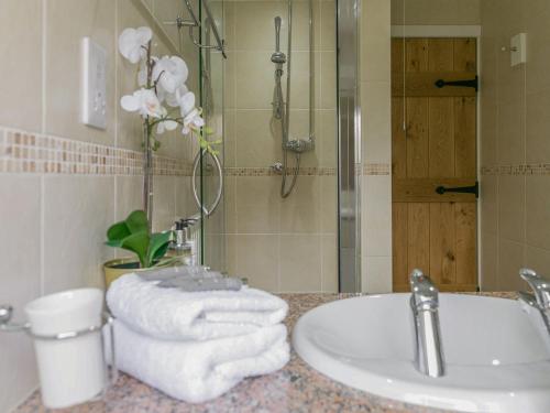 a bathroom with a sink and a shower with towels at Teal in Llangennith