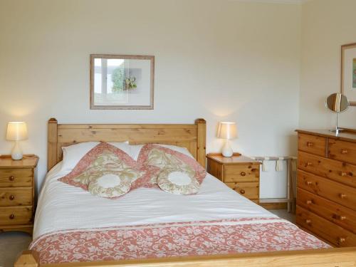 a bedroom with a bed with two pillows on it at Cuillin View in Husabost