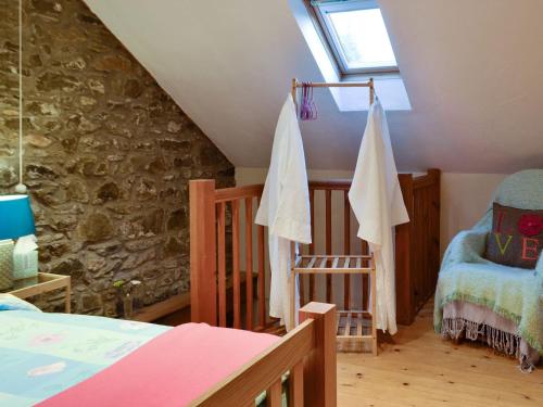 a attic room with a bed and a crib at The Pig Sty in Llanfair-ar-y-bryn
