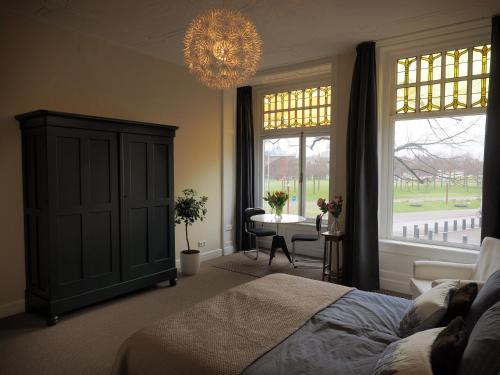 阿姆斯特丹的住宿－M廣場住宿加早餐旅館，一间卧室配有一张床、一张桌子和一个吊灯。