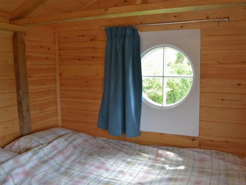 a bedroom with a window in a log cabin at Shepherds Rest in Wedmore
