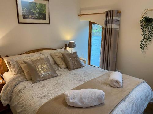 a bedroom with a large bed with a large window at Rivers Edge Cottage in Shotley Bridge
