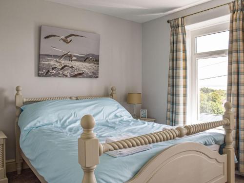 um quarto com uma cama com pássaros voando no ar em Ocean View Cottage em Burry Port