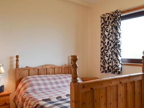 - une chambre avec un lit en bois et une fenêtre dans l'établissement Sealladh Lingeigh, à Pollachar