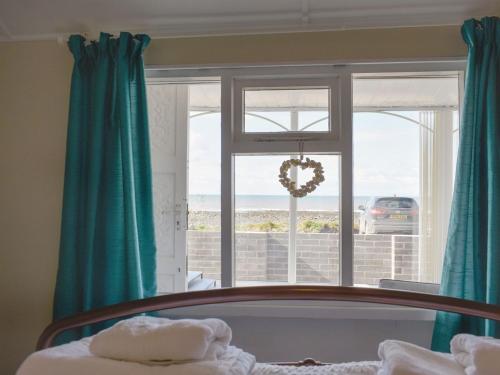 a bedroom with a window with a view of the ocean at Ludlow Bank in Coulderton