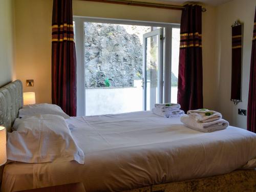 een bed met handdoeken voor een raam bij Seaviews And Hot Tub At The Fairways - Uk39821 in Portpatrick