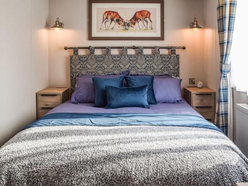 a bedroom with a large bed with blue pillows at Donald's Peak View in Acharra