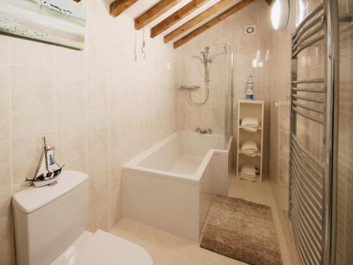 a white bathroom with a tub and a toilet at Chestnut Cottage - E5625 in Wainfleet All Saints