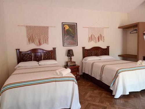 a bedroom with two beds with white sheets at Villas victoria mirador in Zihuatanejo