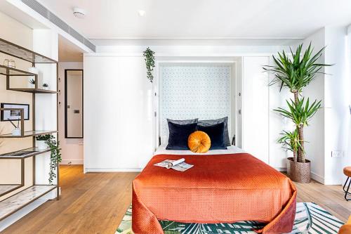 a bedroom with a bed with an orange blanket at Idyllic Covent Garden Flat in London