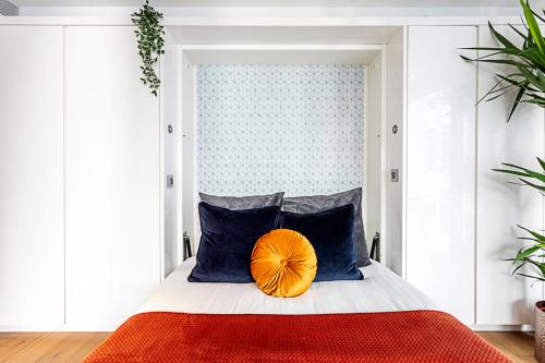 a bedroom with a bed with a orange pillow on it at Idyllic Covent Garden Flat in London