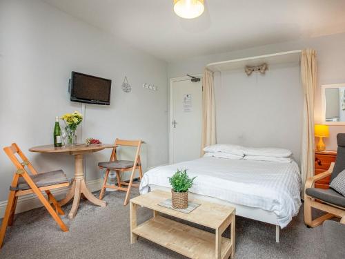 a bedroom with a bed and a table and a desk at Apartment Eleven - Uk39864 in Paignton