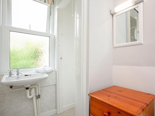 een badkamer met een wastafel en een raam bij Apartment Eleven - Uk39864 in Paignton