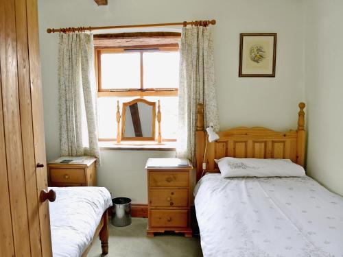 een slaapkamer met 2 bedden en een raam bij Cruck End - E3749 in Crackenthorpe