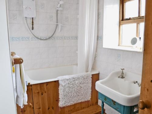 a bathroom with a tub and a sink at Cruck End - E3749 in Crackenthorpe