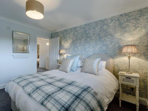 1 dormitorio con 1 cama con pared azul en Old Mead House en Folkestone