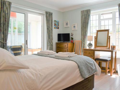 a bedroom with a large bed and a mirror at Ashlea At Amberley in Sidmouth