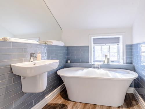 een badkamer met een wit bad en een wastafel bij Well Strand in Rothbury