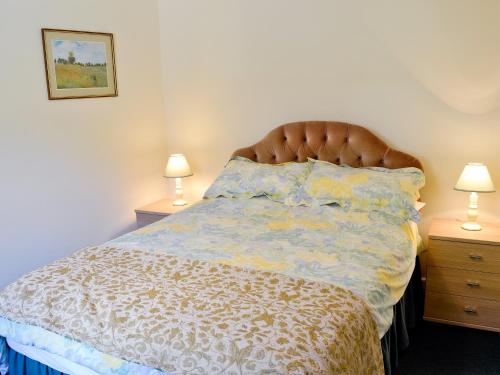 ein Bett in einem Schlafzimmer mit zwei Nachttischen und zwei Lampen in der Unterkunft Pig Sty Cottage - E1867 in Powerstock